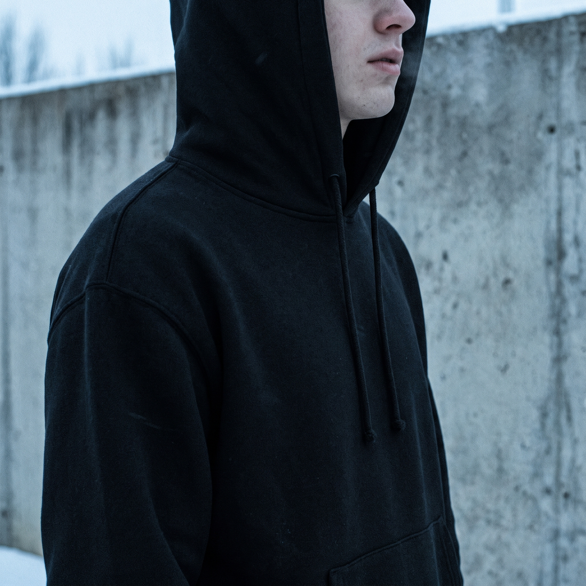 Rider with hood up in a black AFS hoodie, cold winter light