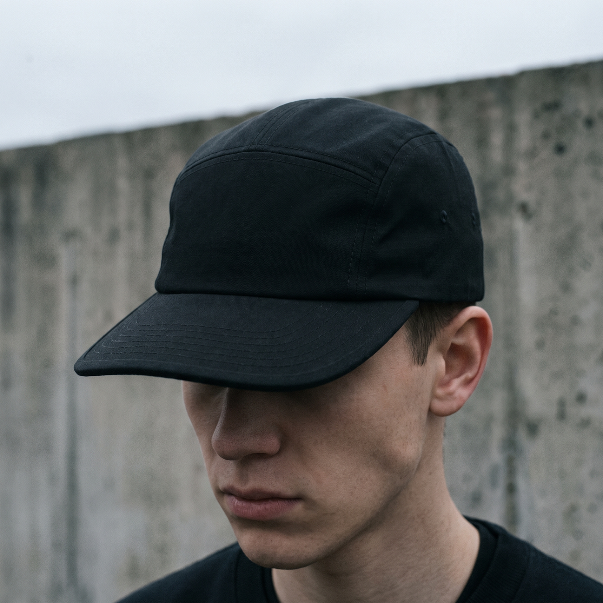 Black five-panel AFS cap against concrete